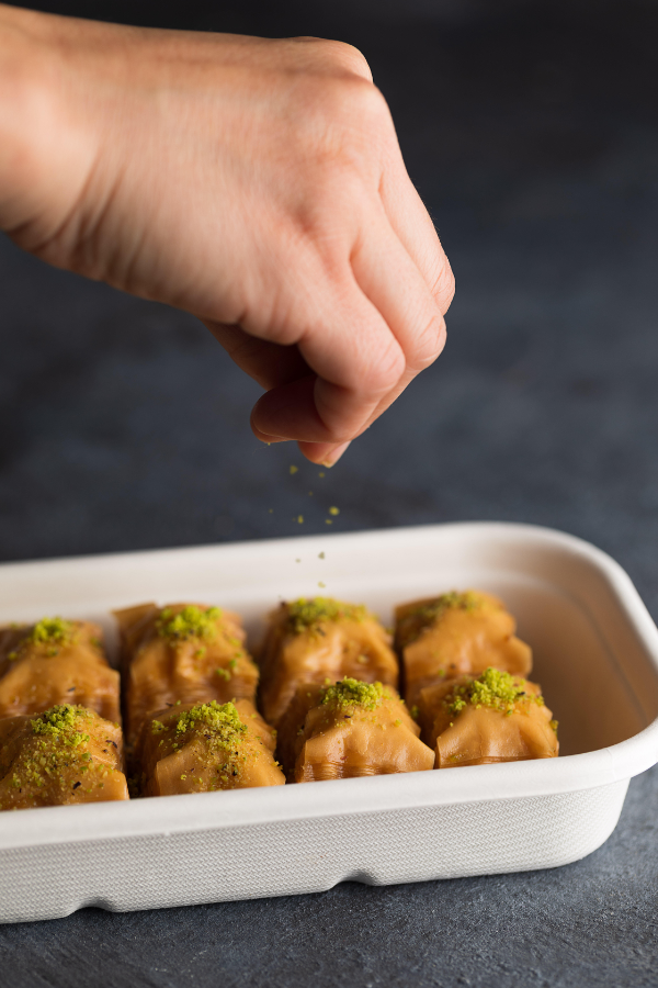 Baklava being finished with pistachio